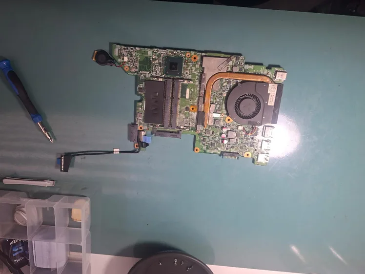 Placa-mãe de notebook Dell fora do aparelho, com o heat pipe de cobre ligado ao cooler