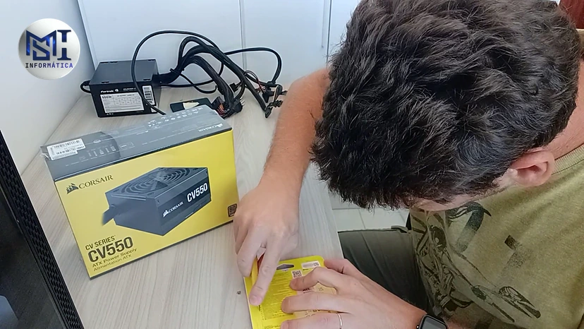 Marcello Di Silvestro abrindo a caixa de uma fonte Corsair CV550 nova para o PC de um cliente, no vídeo do canal
