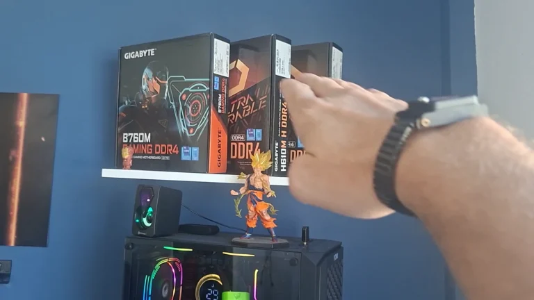Mão do técnico nas caixas de placa-mãe B760M e H610M numa estante, acima de um PC gamer com water cooler aceso