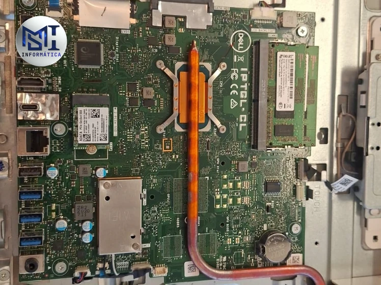 Placa-mãe de um Dell All-in-One com o tubo de cobre do dissipador, o pente de memória e a bateria redonda da BIOS