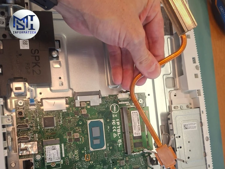 Dissipador com heatpipe de cobre sendo retirado da placa-mãe de um Dell All-in-One durante a limpeza