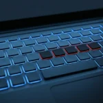 Teclado de notebook em close com a maioria das teclas acesas em azul e algumas apagadas em vermelho