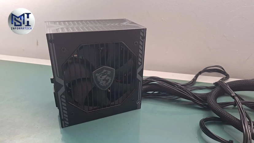Fonte MSI MAG A650BN de 650 W vista pelo lado da ventoinha, com os cabos saindo pela lateral