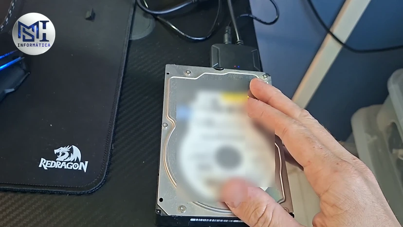 HD mecânico antigo de 3,5 polegadas ligado por cabo, na mão do técnico, no vídeo do canal