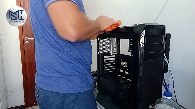 Marcello Di Silvestro limpando o gabinete de um PC de cliente com pano de microfibra, no vídeo do canal