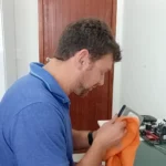 Marcello Di Silvestro limpando uma peça de um PC de cliente com pano de microfibra, durante a limpeza interna
