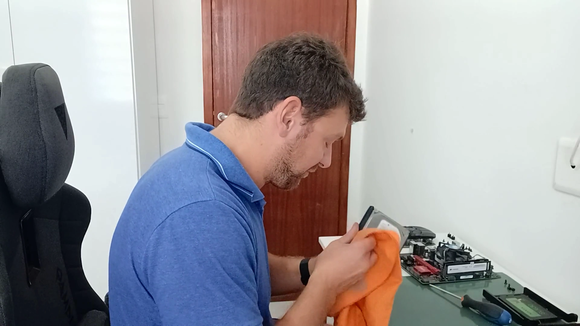 Marcello Di Silvestro limpando uma peça de um PC de cliente com pano de microfibra, durante a limpeza interna