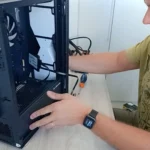 Marcello Di Silvestro montando um PC de cliente, com o gabinete aberto sobre a mesa