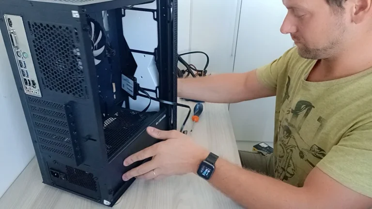 Marcello Di Silvestro montando um PC de cliente, com o gabinete aberto sobre a mesa