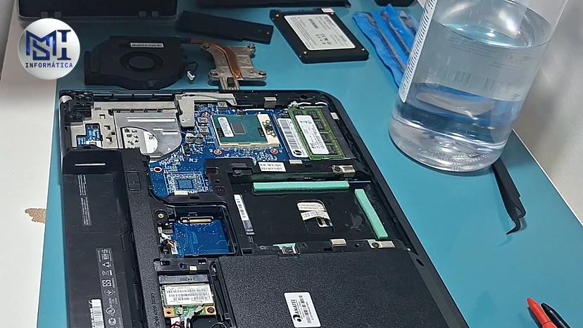 Notebook Lenovo aberto por baixo na manutenção, com o cooler e o tubo de cobre do dissipador à mostra, no vídeo do canal