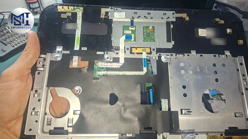Notebook Dell aberto sem o teclado, com os cabos flat e as chapas presas por parafusos: a manutenção do notebook dá mais trabalho
