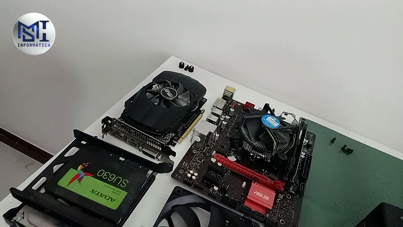 Placa de vídeo, placa-mãe com o cooler do processador e SSD SATA ADATA de um PC de cliente sobre a mesa, durante a manutenção, no vídeo do canal