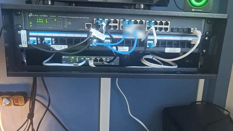 Rack de rede do escritório da MSI com switch gerenciável, patch panel identificado por setor e roteador