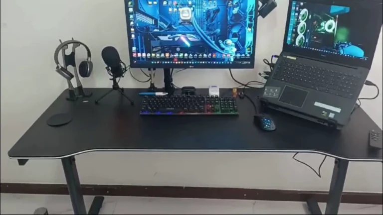 Setup do canal: mesa gamer preta com monitor LG, teclado mecânico com luz, mouse, headset no suporte, microfone e notebook