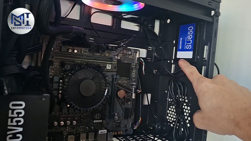 SSD SATA ADATA SU650 instalado no gabinete de um PC, com o dedo do técnico apontando, no vídeo do canal