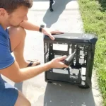 Marcello Di Silvestro tirando a poeira de um gabinete de PC com o soprador, do lado de fora de casa