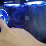 Dedo do técnico apontando a ventoinha traseira acesa de um PC gamer com ventoinhas azuis no topo
